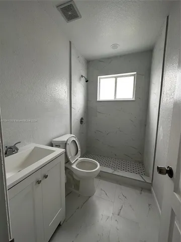a bathroom with a toilet sink and shower