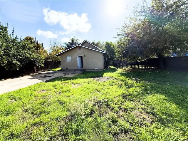 a view of a house with a yard and tree s