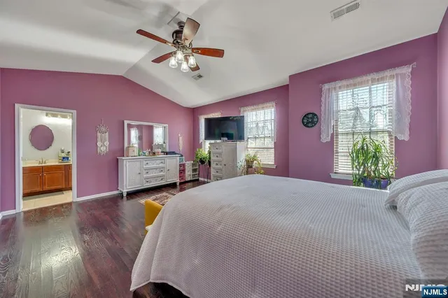 a spacious bedroom with a bed and a chandelier