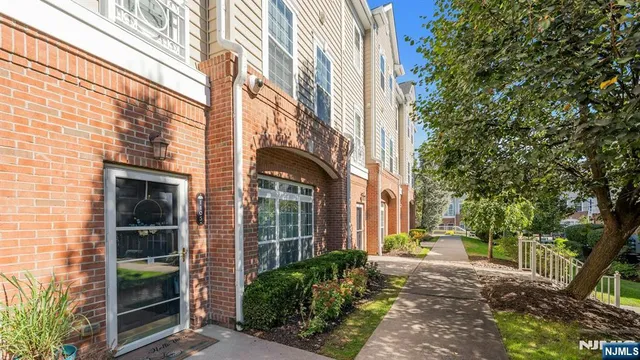a view of a brick house with a large windows and plants