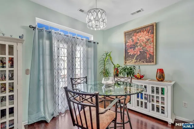 a dining room with furniture a chandelier and wooden floor