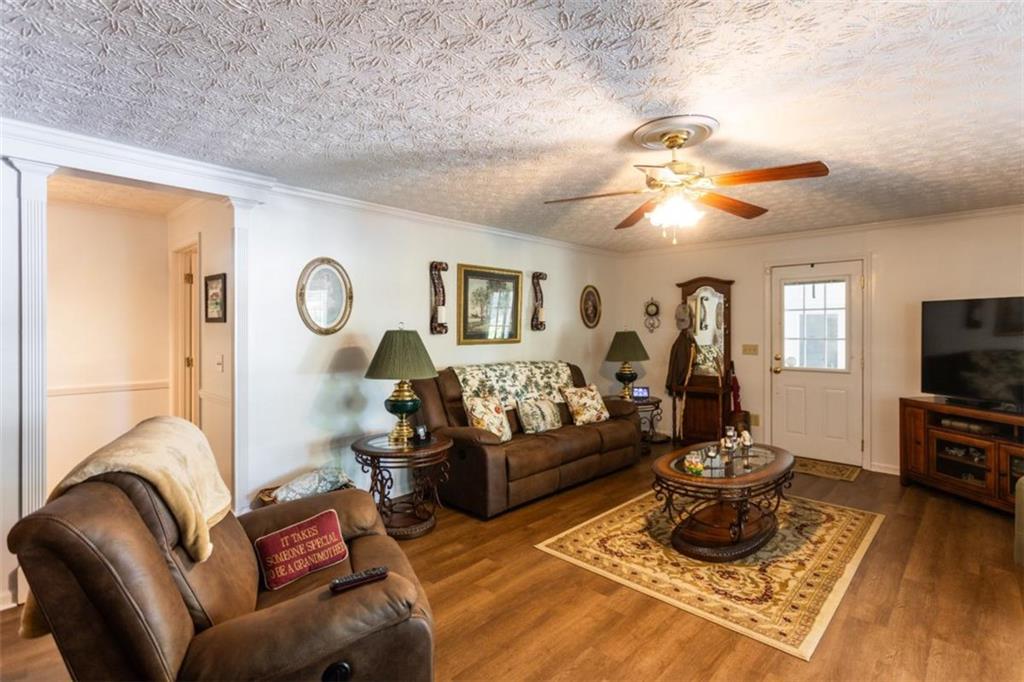 116 East Fulton Street Newborn, GA 30056 - Photo 19 of 74 a living room with furniture a flat screen tv and a chandelier