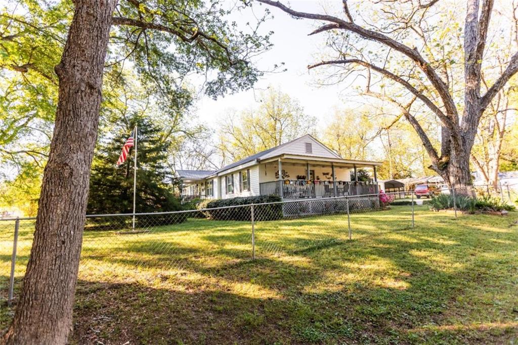 116 East Fulton Street Newborn, GA 30056 - Photo 2 of 74 a view of a house with a big yard and large trees