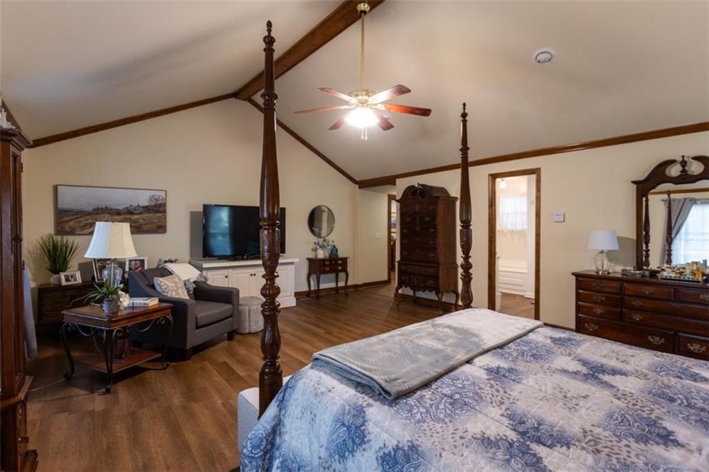 116 East Fulton Street Newborn, GA 30056 - Photo 47 of 74 a spacious bedroom with a bed a chandelier and a flat tv screen on the dresser