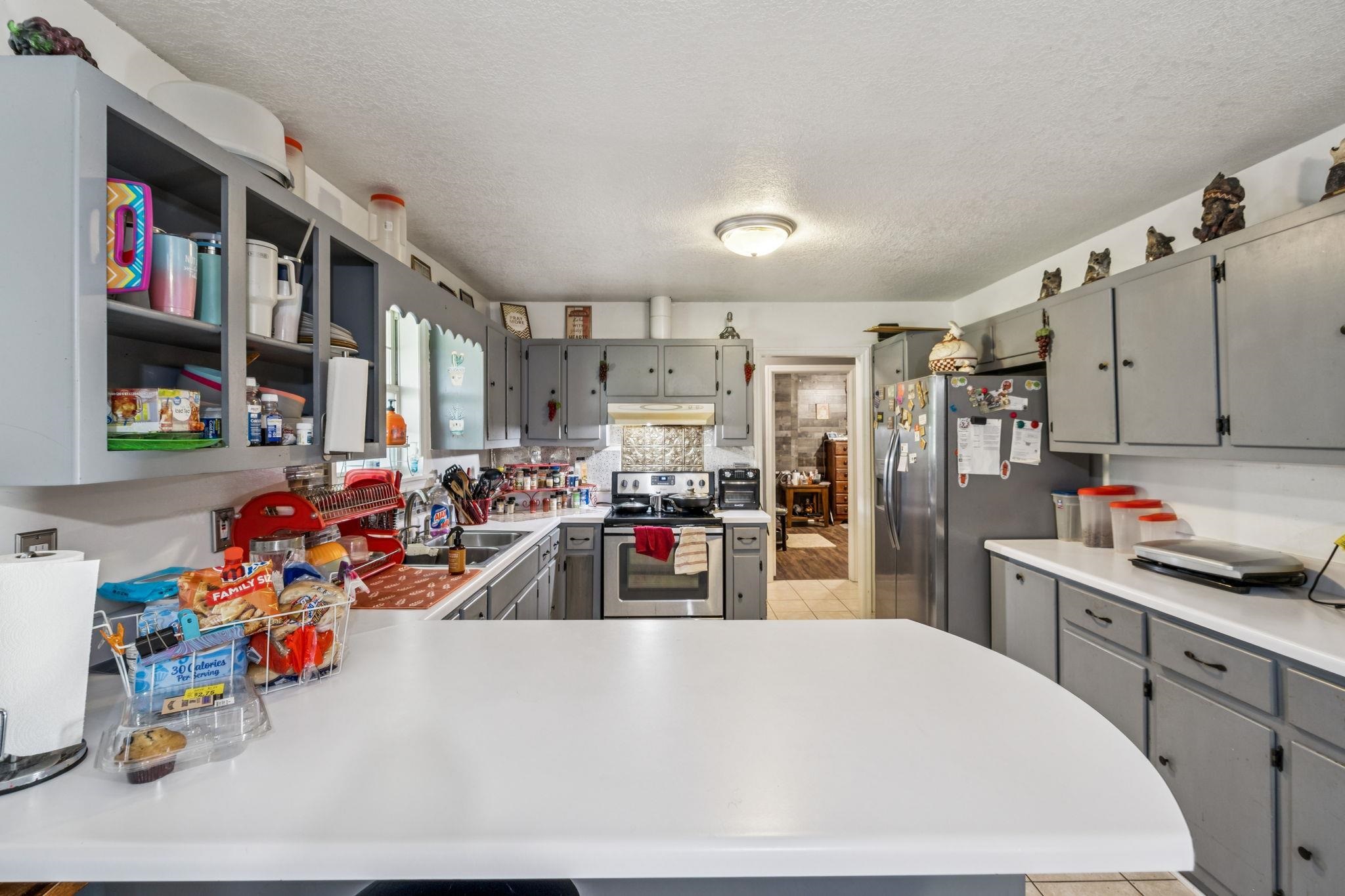 537 Isbell Lane Decherd, TN 37324 - Photo 11 of 40 a large white kitchen with lots of clutter and refrigerator
