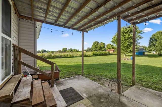 a view of a porch with furniture and a yard