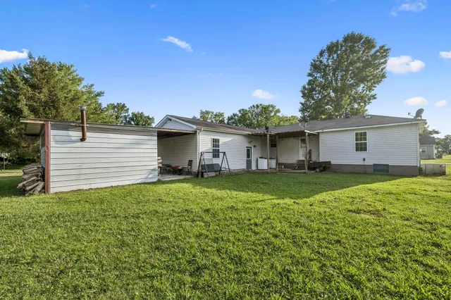 a view of a house with backyard and a tree