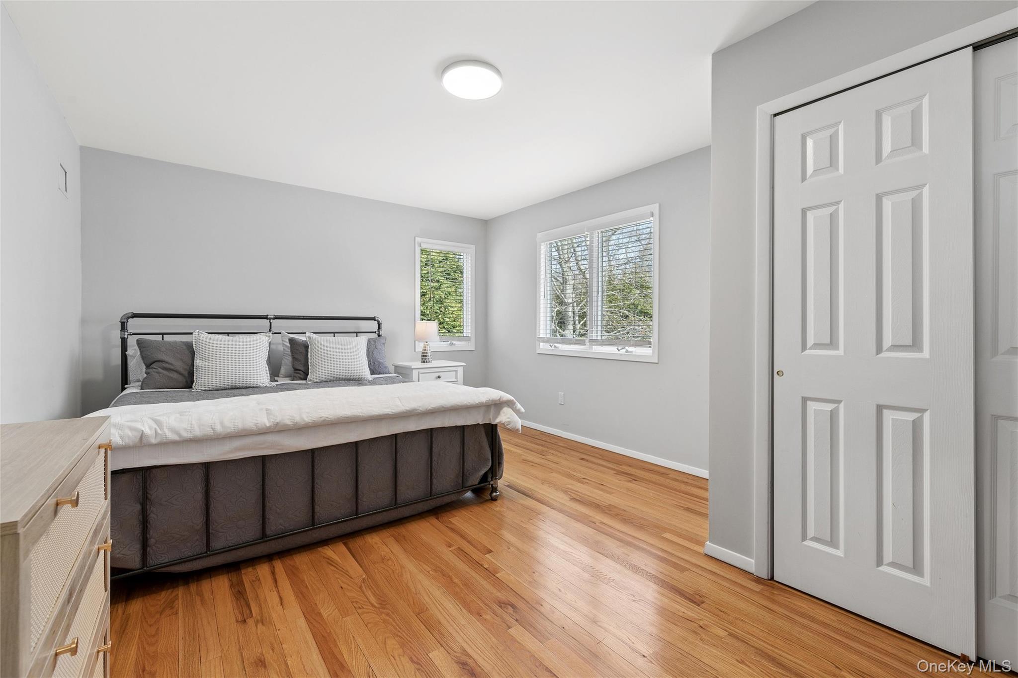 131 Lewis Road East Quogue, NY 11942 - Photo 13 of 25 a bedroom with a bed and wooden floor