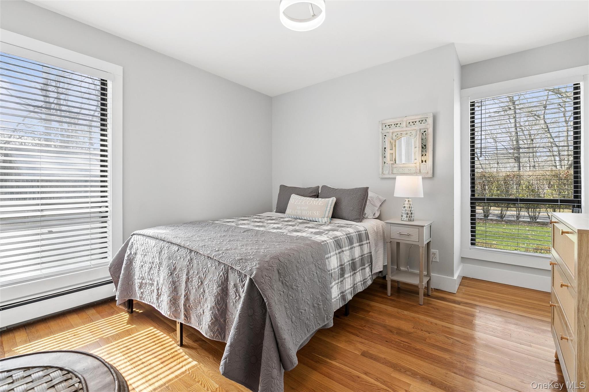 131 Lewis Road East Quogue, NY 11942 - Photo 15 of 25 a bedroom with a bed and wooden floor