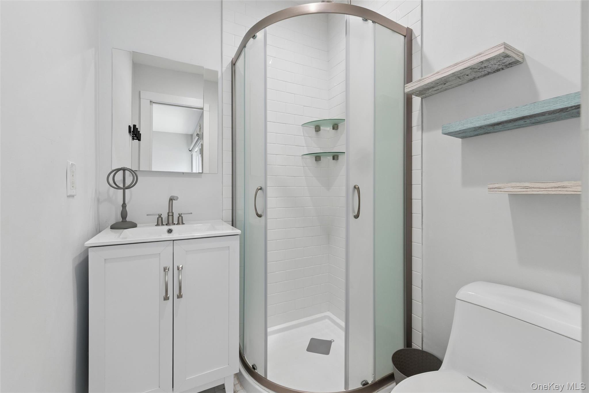 131 Lewis Road East Quogue, NY 11942 - Photo 16 of 25 a bathroom with a sink a toilet and shower