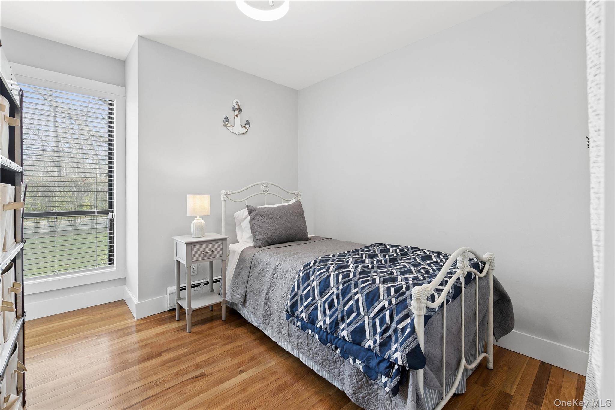 131 Lewis Road East Quogue, NY 11942 - Photo 17 of 25 a bedroom with a bed and wooden floor