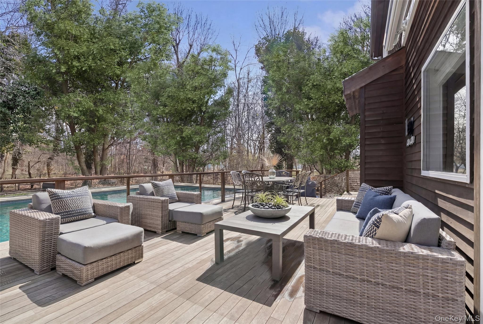 131 Lewis Road East Quogue, NY 11942 - Photo 18 of 25 a view of a patio with couches and a table and chairs with wooden floor and fence