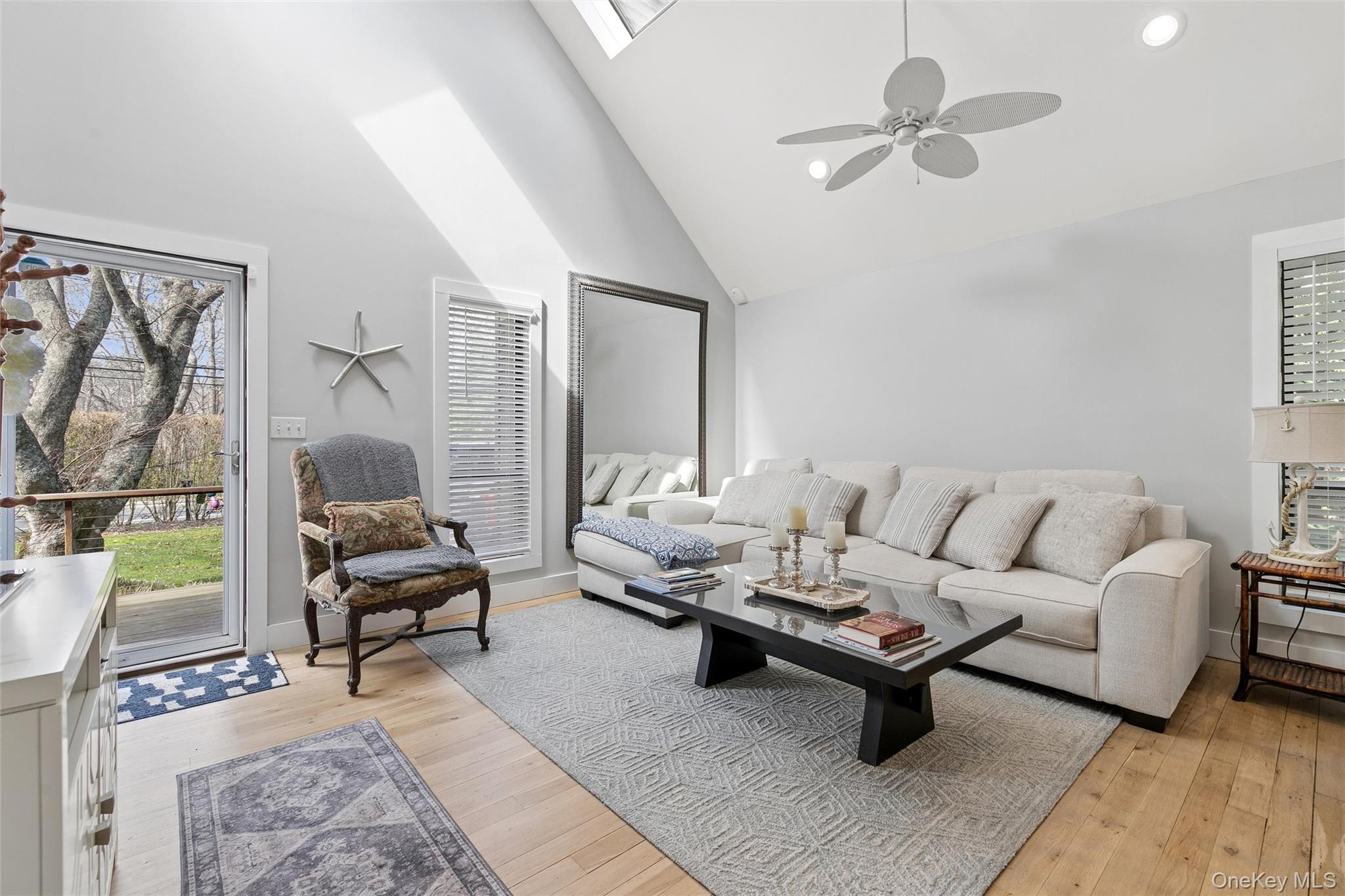 131 Lewis Road East Quogue, NY 11942 - Photo 5 of 25 a living room with furniture a rug potted plant and a large window