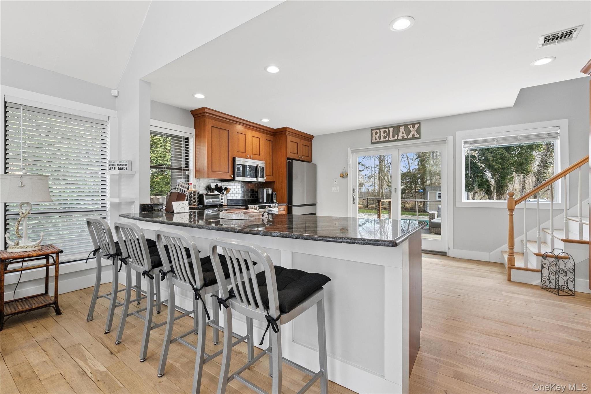 131 Lewis Road East Quogue, NY 11942 - Photo 7 of 25 a kitchen with granite countertop a table chairs stove and sink