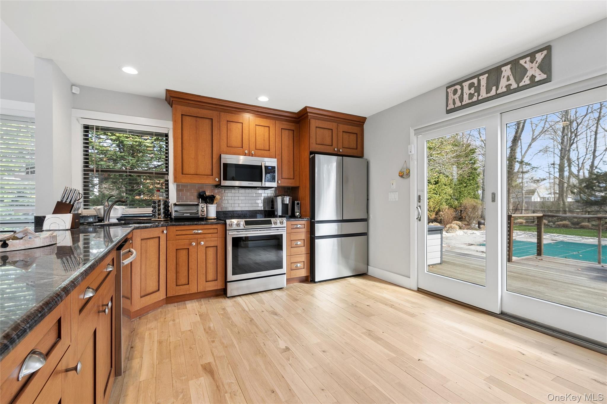 131 Lewis Road East Quogue, NY 11942 - Photo 8 of 25 a kitchen with granite countertop a refrigerator and a stove top oven