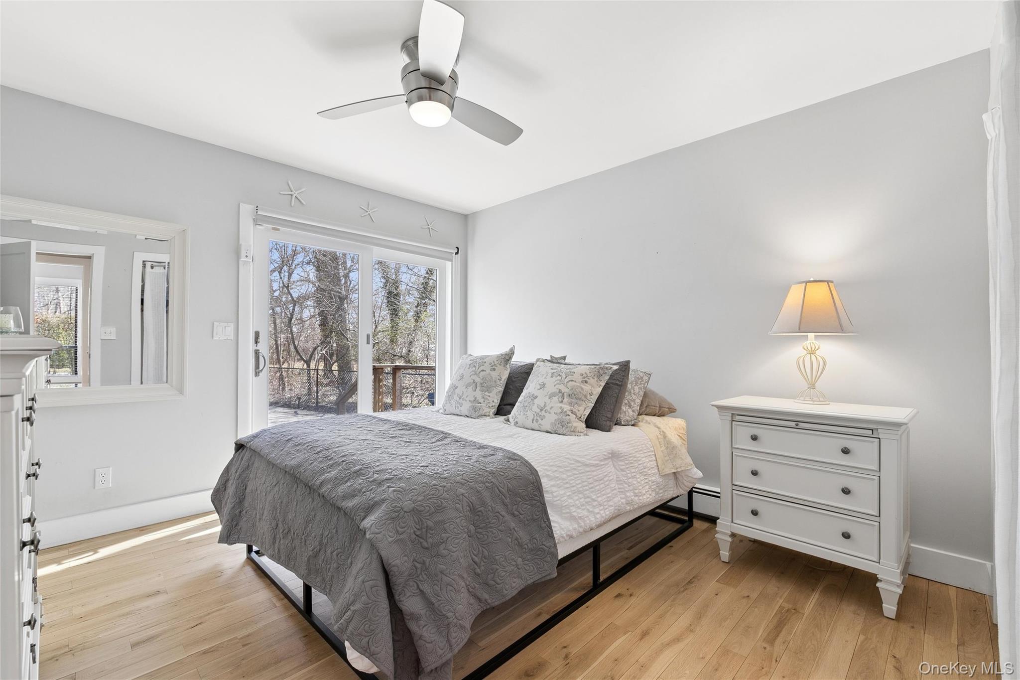 131 Lewis Road East Quogue, NY 11942 - Photo 10 of 25 a bedroom with a bed and wooden floor