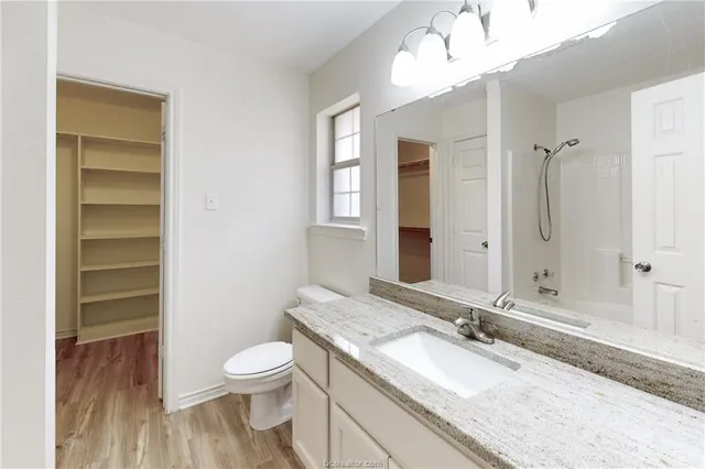 a bathroom with a granite countertop sink toilet a large mirror and shower