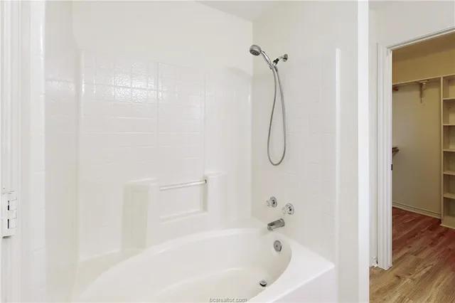 a bathroom with a bath tub with a shower