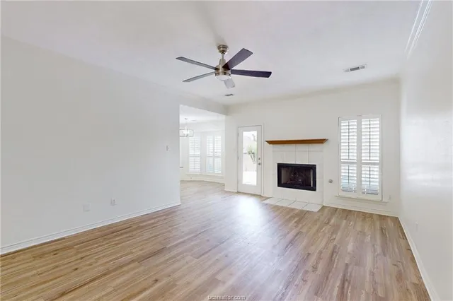 wooden floor fireplace and windows in an empty room