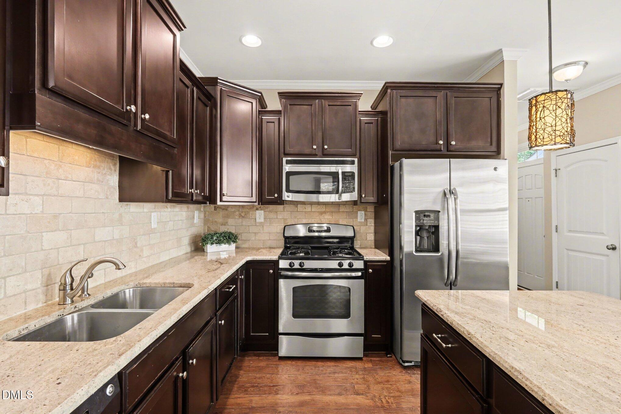 2409 Memory Ridge Drive Raleigh, NC 27606 - Photo 10 of 36 a kitchen with stainless steel appliances granite countertop a sink stove and refrigerator