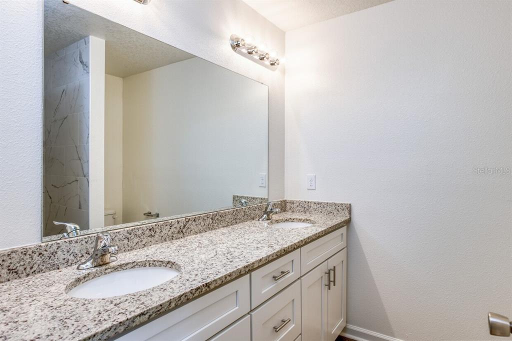4840 Kenneth Street Hastings, FL 32145 - Photo 7 of 22 a bathroom with a granite countertop sink and a mirror