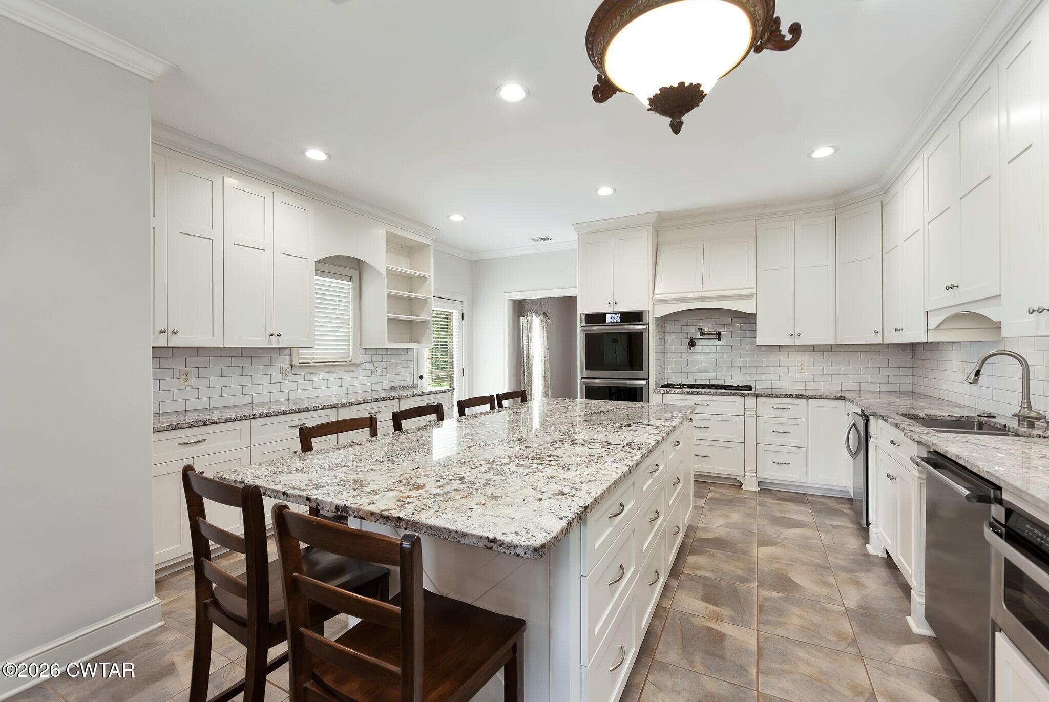 4080 Beech Bluff Road Beech Bluff, TN 38313 - Photo 16 of 41 a kitchen with granite countertop a stove a sink a counter space and cabinets