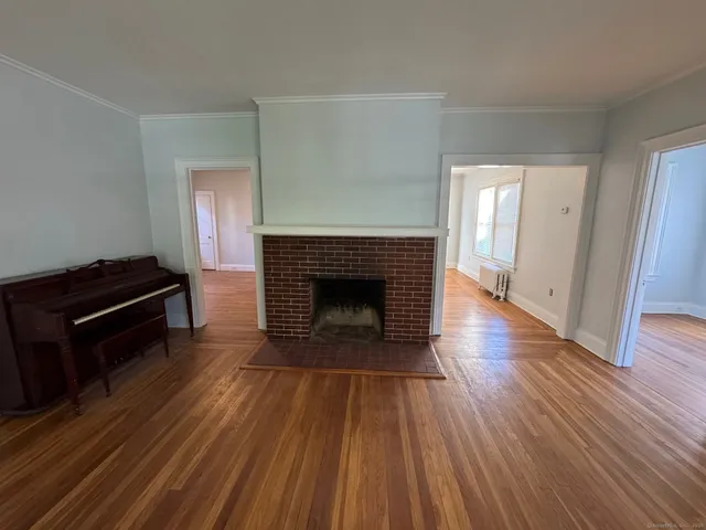 a living room with wooden floor and a fireplace