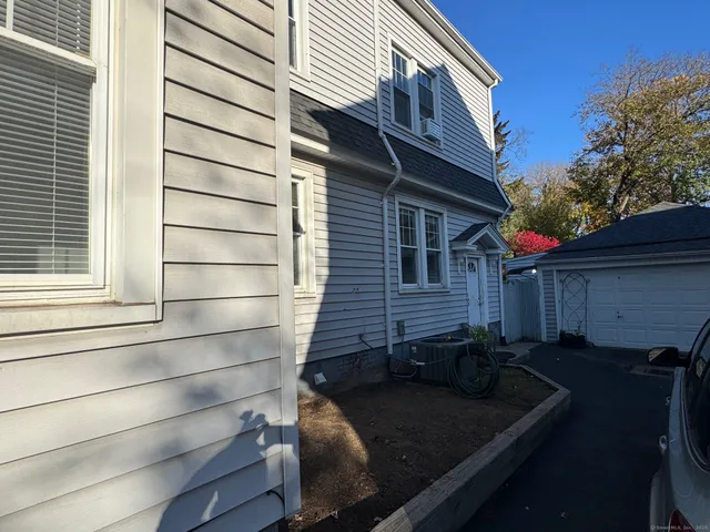 a backyard of a house with wooden fence and large trees