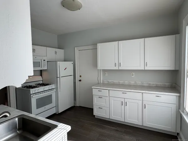 a kitchen with white cabinets and white appliances