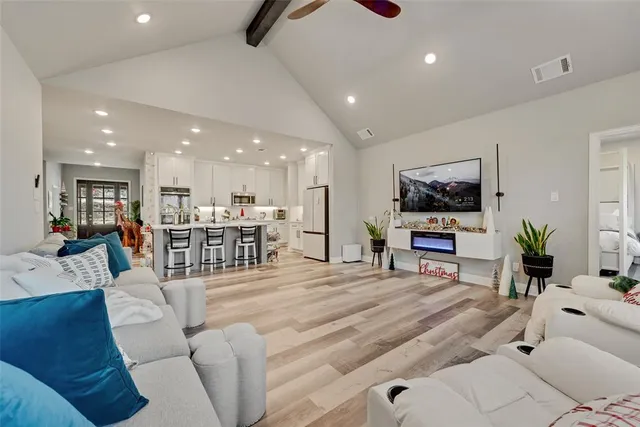 a living room with furniture a flat screen tv and kitchen view
