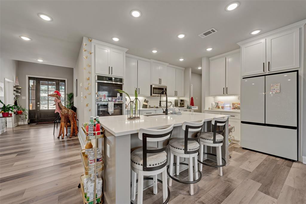 421 Ridgeview Road Sherman, TX 75092 - Photo 14 of 35 a kitchen with stainless steel appliances kitchen island granite countertop a dining table chairs refrigerator and sink