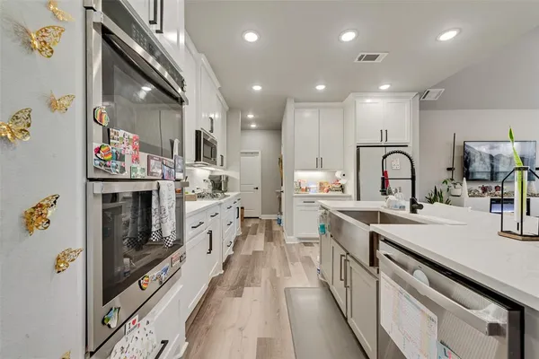 a large kitchen with stainless steel appliances granite countertop a lot of counter space and a sink