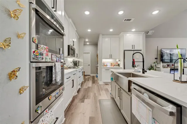 a large kitchen with stainless steel appliances granite countertop a lot of counter space and a sink