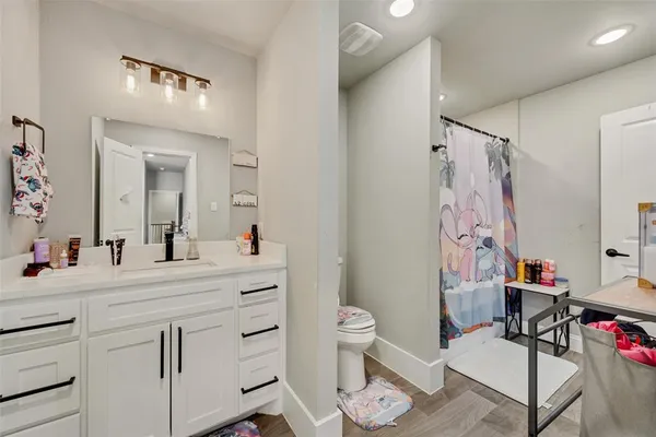 a bathroom with a sink vanity mirror and toilet
