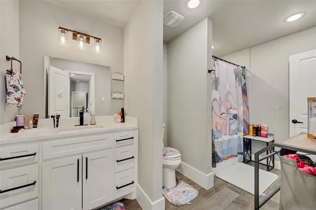 a bathroom with a sink vanity mirror and toilet