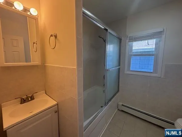 a bathroom with a granite countertop sink and a shower