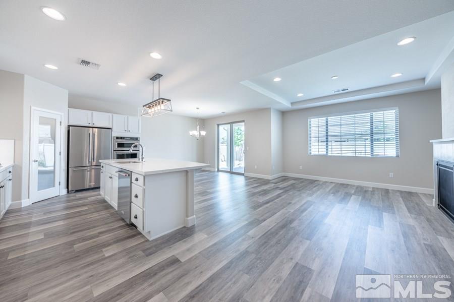 2417 Silver Maple Drive Reno, NV 89521 - Photo 11 of 38 a view of kitchen with refrigerator microwave and wooden floor