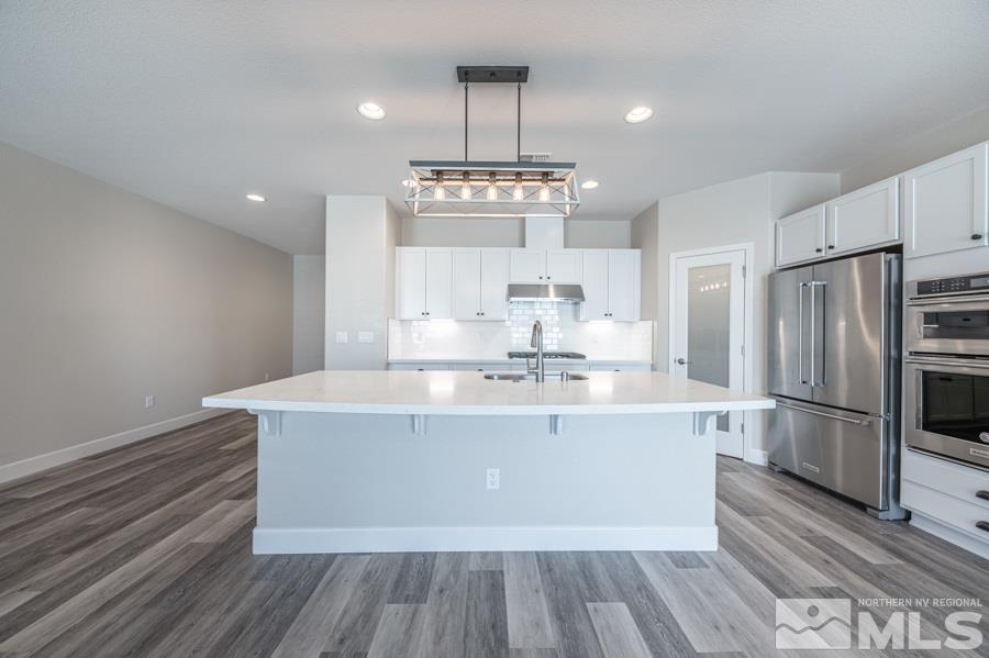 2417 Silver Maple Drive Reno, NV 89521 - Photo 16 of 38 a view of a kitchen with kitchen island a counter top space stainless steel appliances and wooden floor