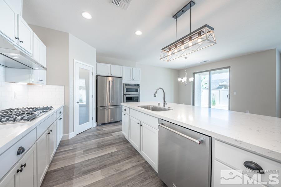 2417 Silver Maple Drive Reno, NV 89521 - Photo 18 of 38 a kitchen with stainless steel appliances granite countertop a sink stove and refrigerator