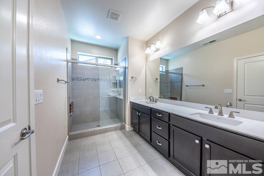 2417 Silver Maple Drive Reno, NV 89521 - Photo 20 of 38 a bathroom with a double vanity sink mirror and shower