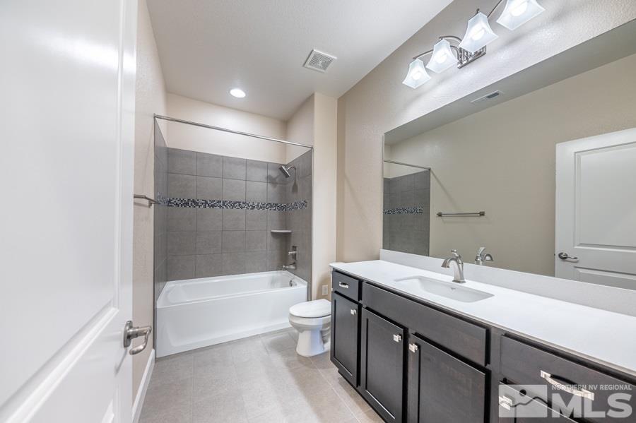 2417 Silver Maple Drive Reno, NV 89521 - Photo 24 of 38 a bathroom with a double vanity sink toilet mirror and bathtub