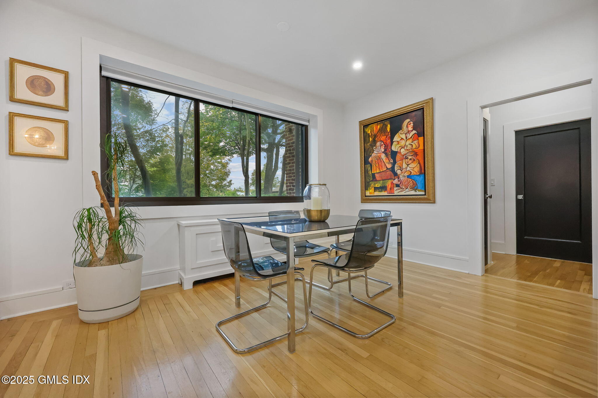 47 Lafayette Place, Unit 1H Greenwich, CT 06830 - Photo 2 of 23 a dining room with wooden floor a glass table and chairs
