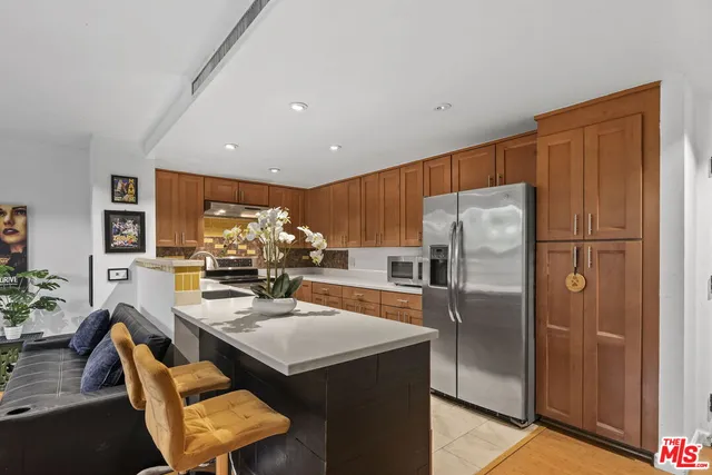 a kitchen with stainless steel appliances granite countertop a refrigerator and a stove
