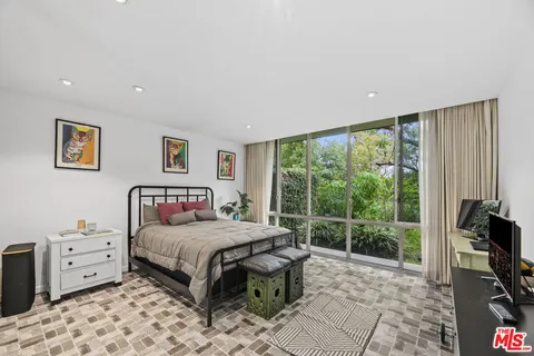 a bedroom with a bed and a view of living room