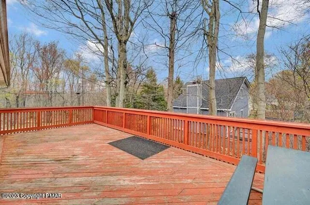 a view of a balcony with wooden floor and fence and a floor to ceiling window