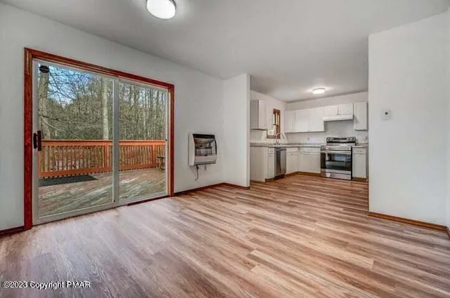 a view of a room with wooden floor and window