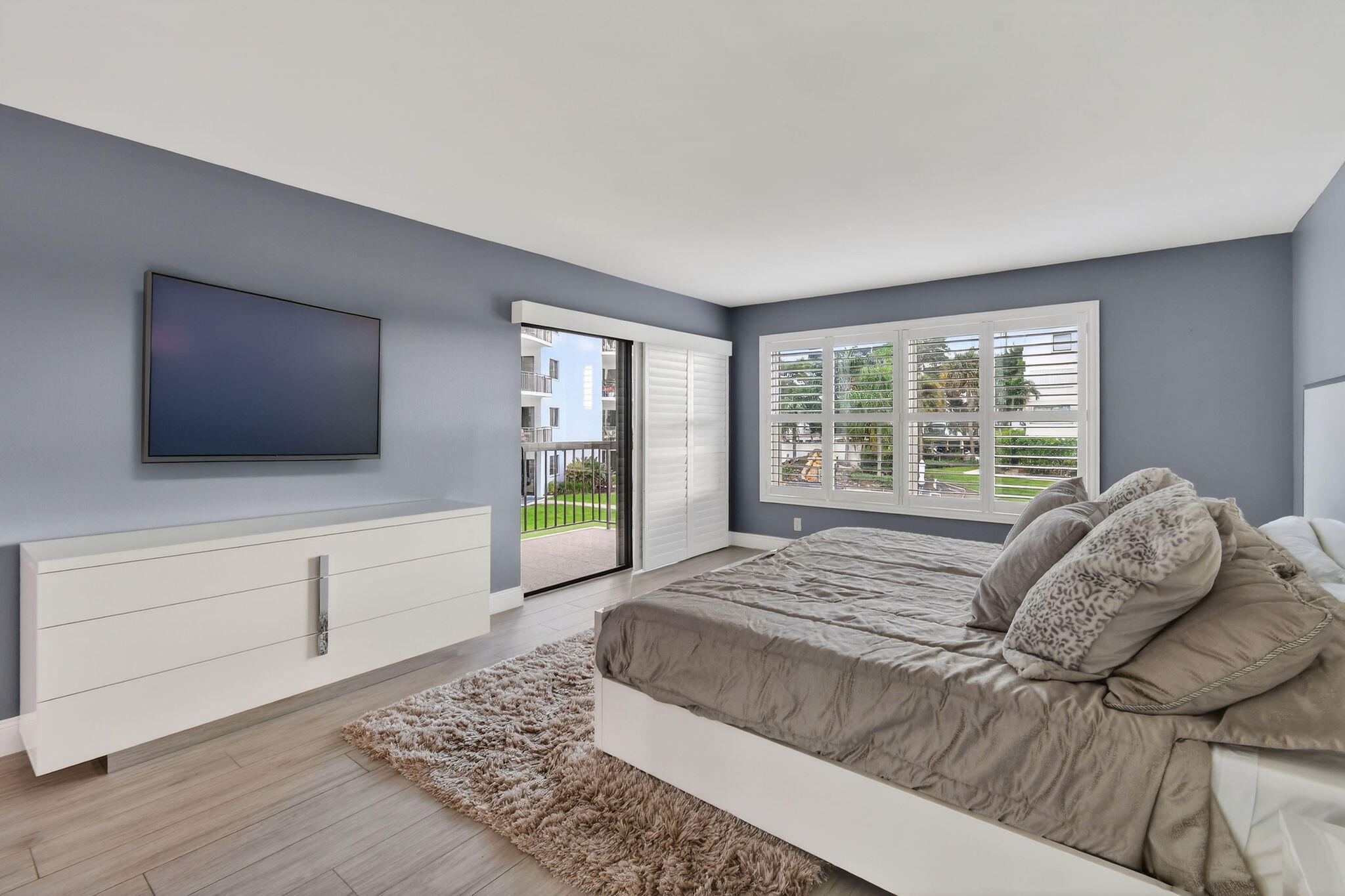 372 Golfview Road, Unit 201 North Palm Beach, FL 33408 - Photo 15 of 45 a bed sitting in a bedroom next to a window with a flat screen tv