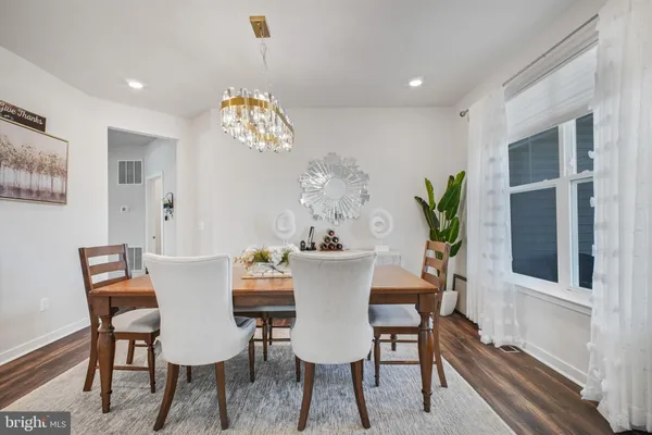a view of a dining room with furniture a chandelier and wooden floor