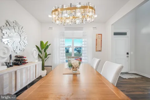 a view of a dining room with furniture a chandelier and wooden floor