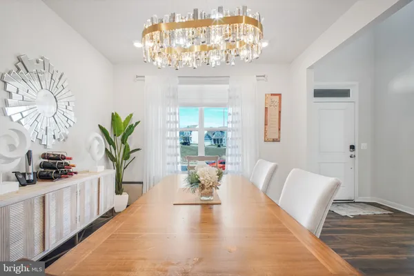 a view of a dining room with furniture a chandelier and wooden floor